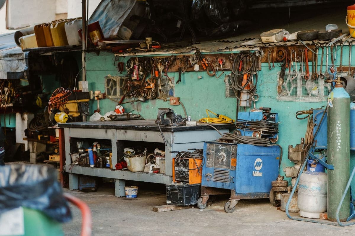 A cluttered workshop with tools and storage along the wall