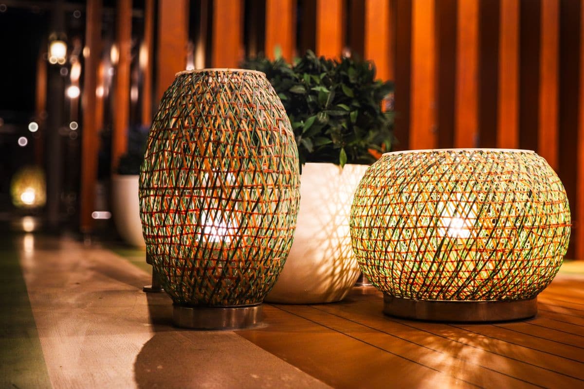 Woven lanterns casting warm light over a wooden patio at night