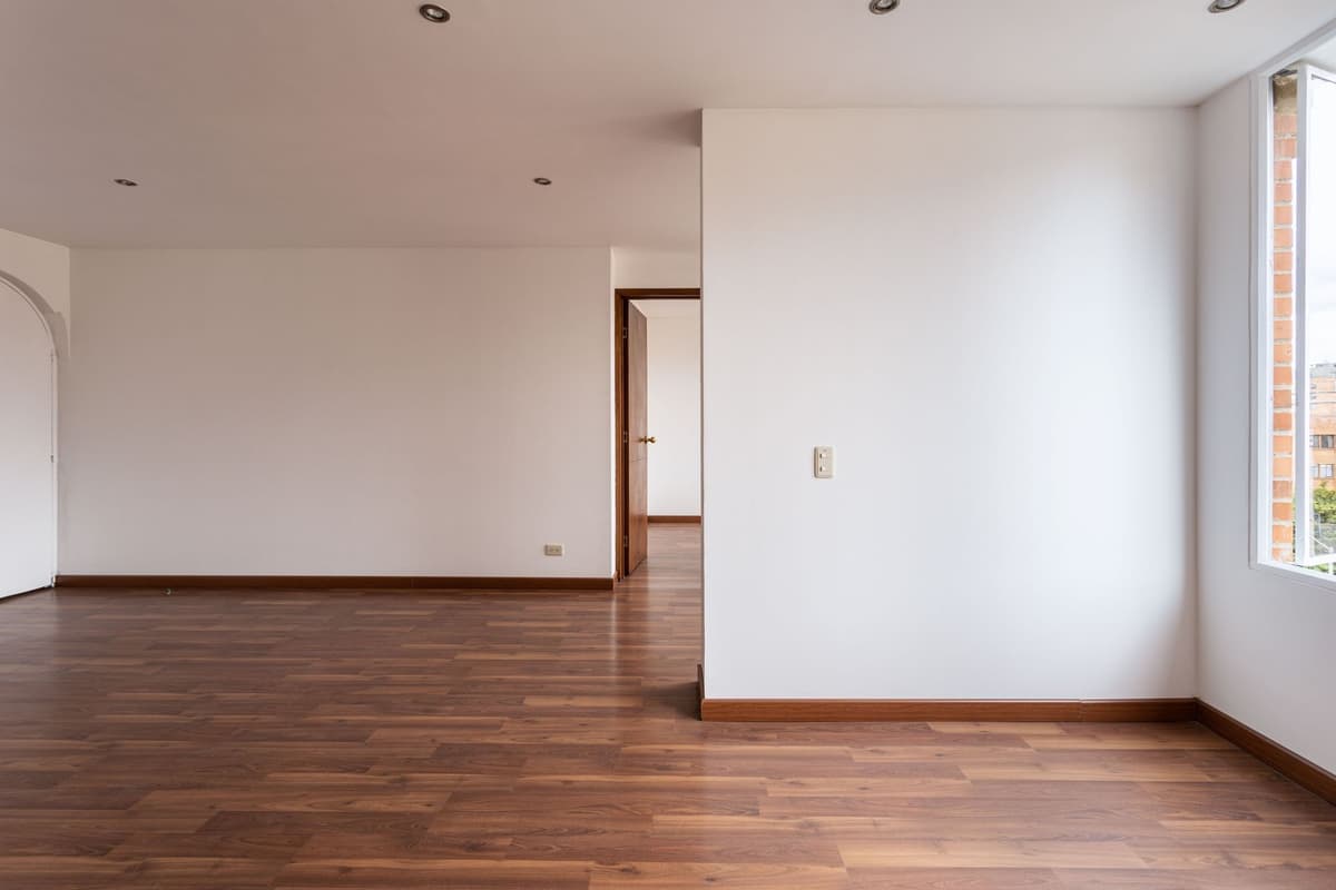 Baseboard and wooden flooring along the wall of an empty room