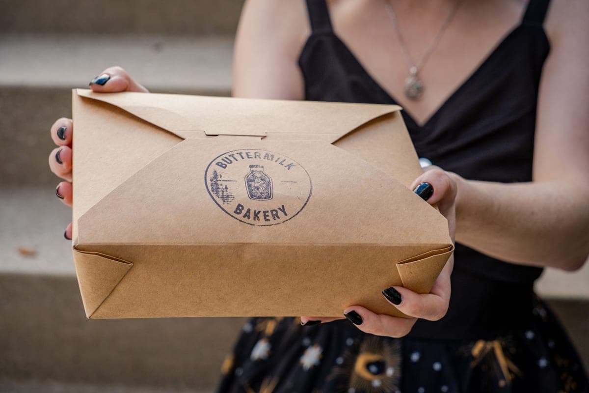 A person carrying a cardboard box outdoors