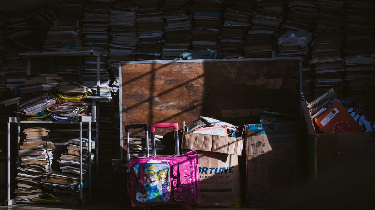 A dimly lit room with stacks of books and boxes