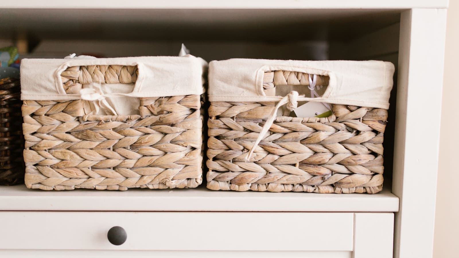 Woven storage baskets arranged neatly on a white shelf