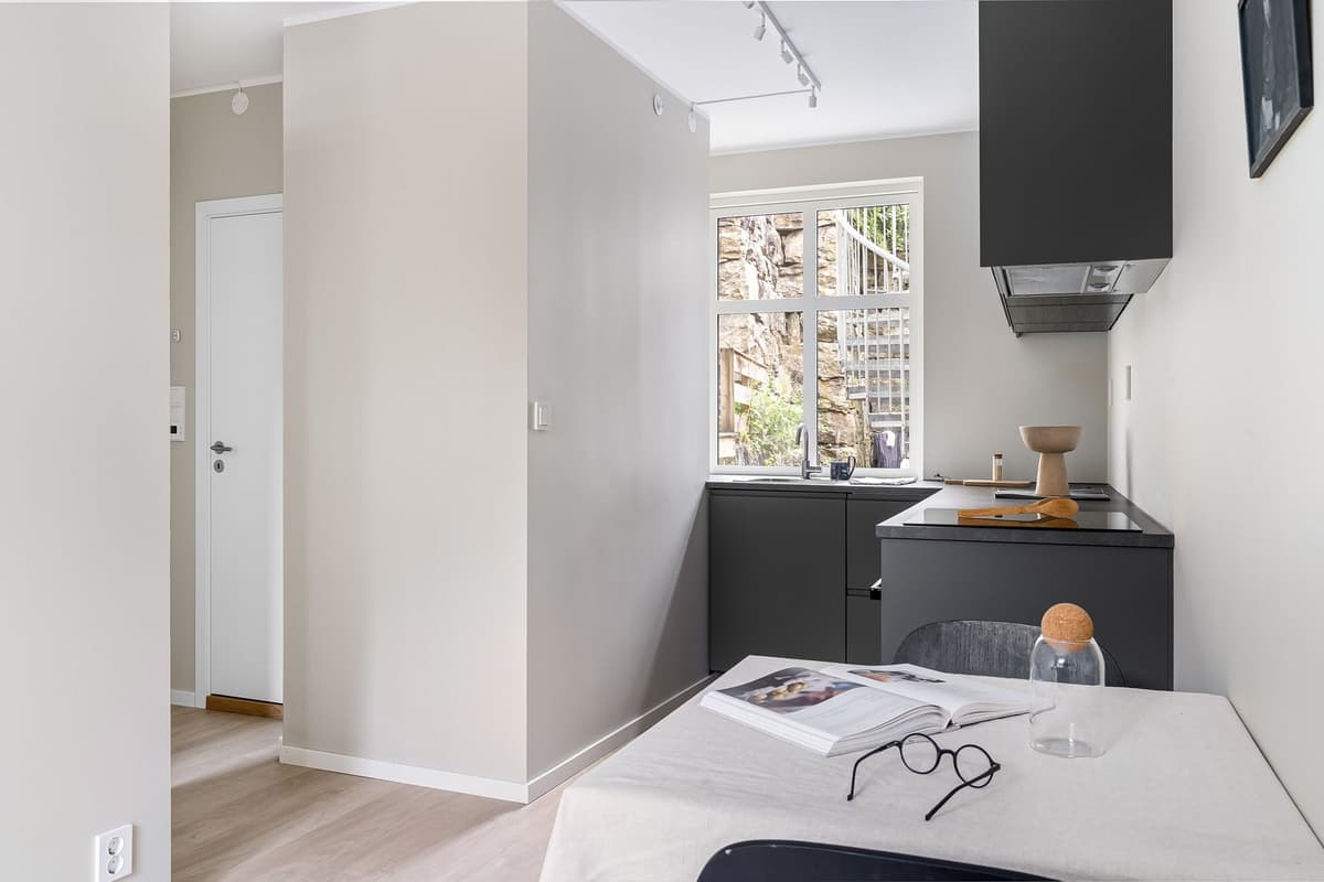 A small modern kitchen with minimal cabinetry and natural light