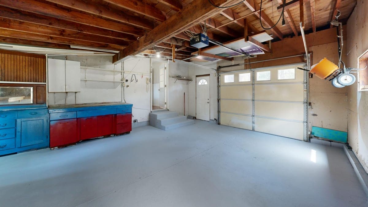 An empty garage with open space and storage cabinets