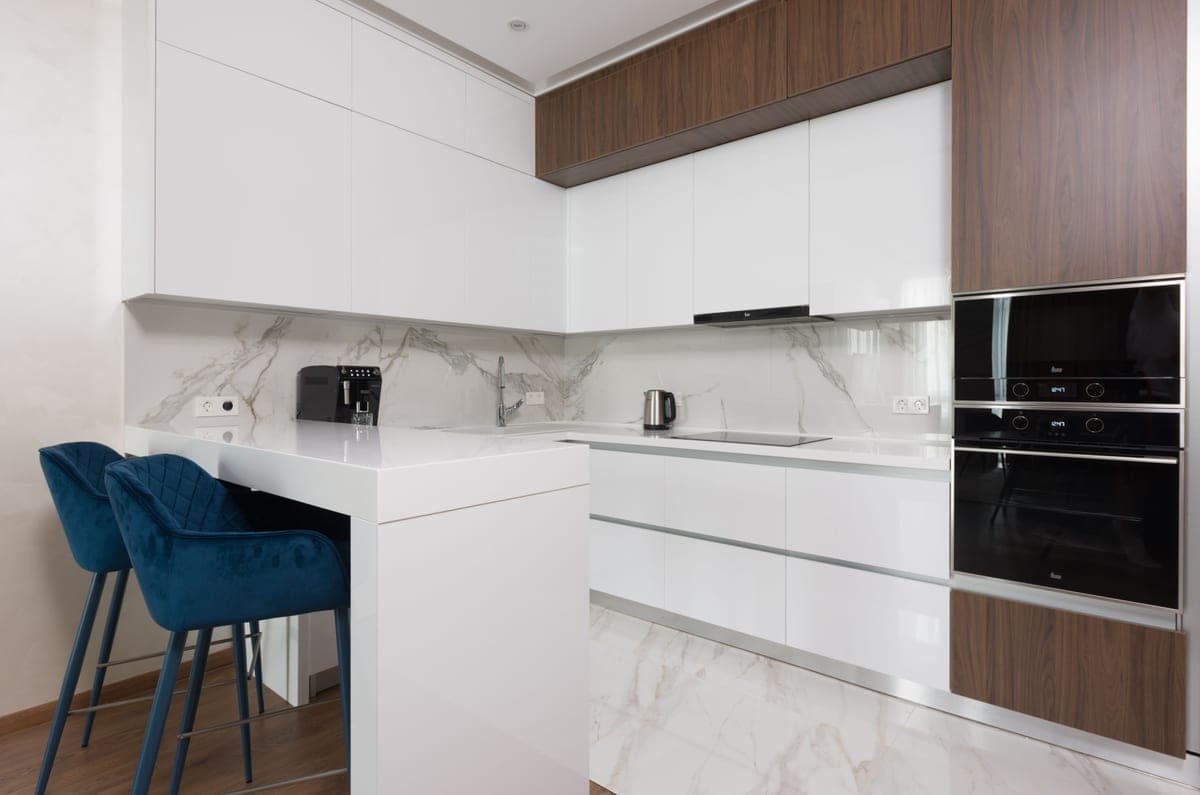 A light modern kitchen with a dining table and appliances