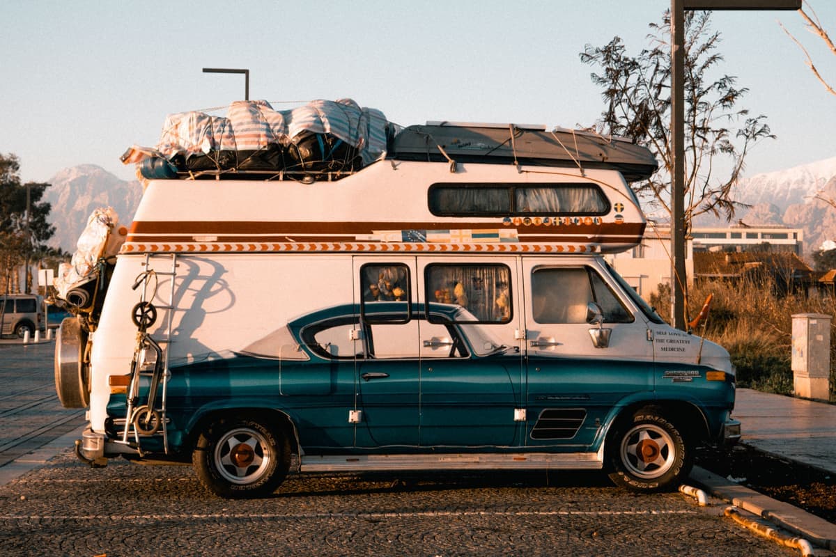 A retro camper van loaded for a trip at sunset