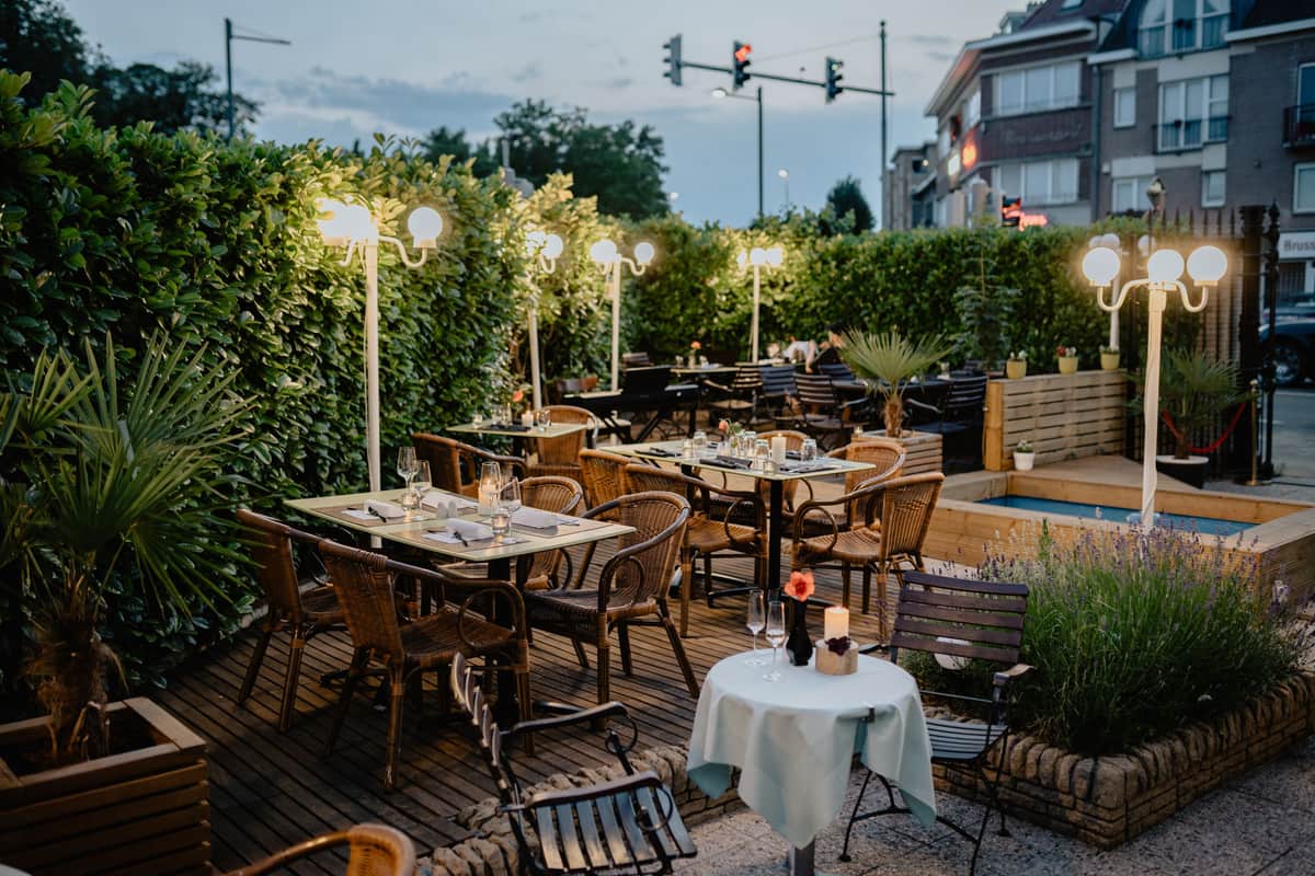 An outdoor terrace with wooden furniture and warm lighting