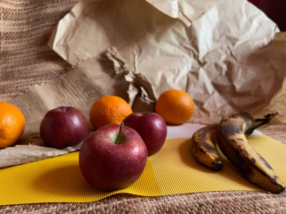 Apples, oranges and bananas arranged on a textured surface