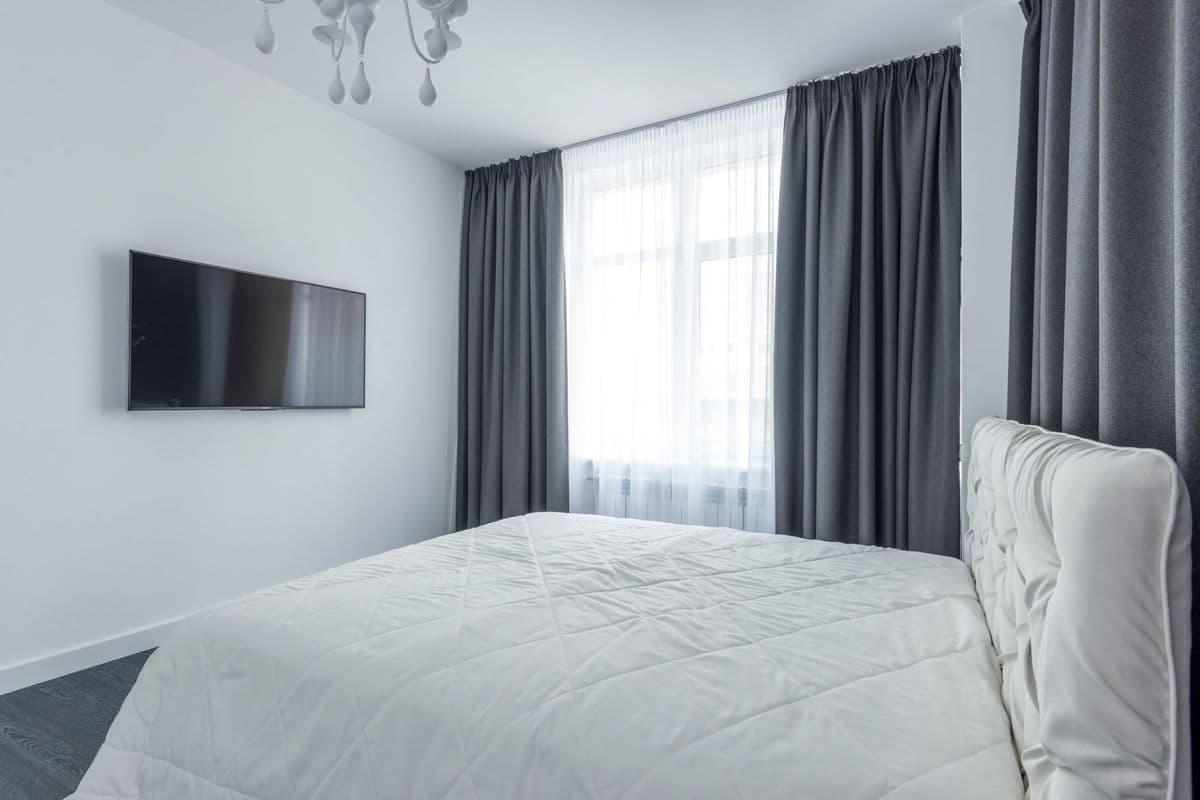 A bedroom with curtains drawn across a window at night