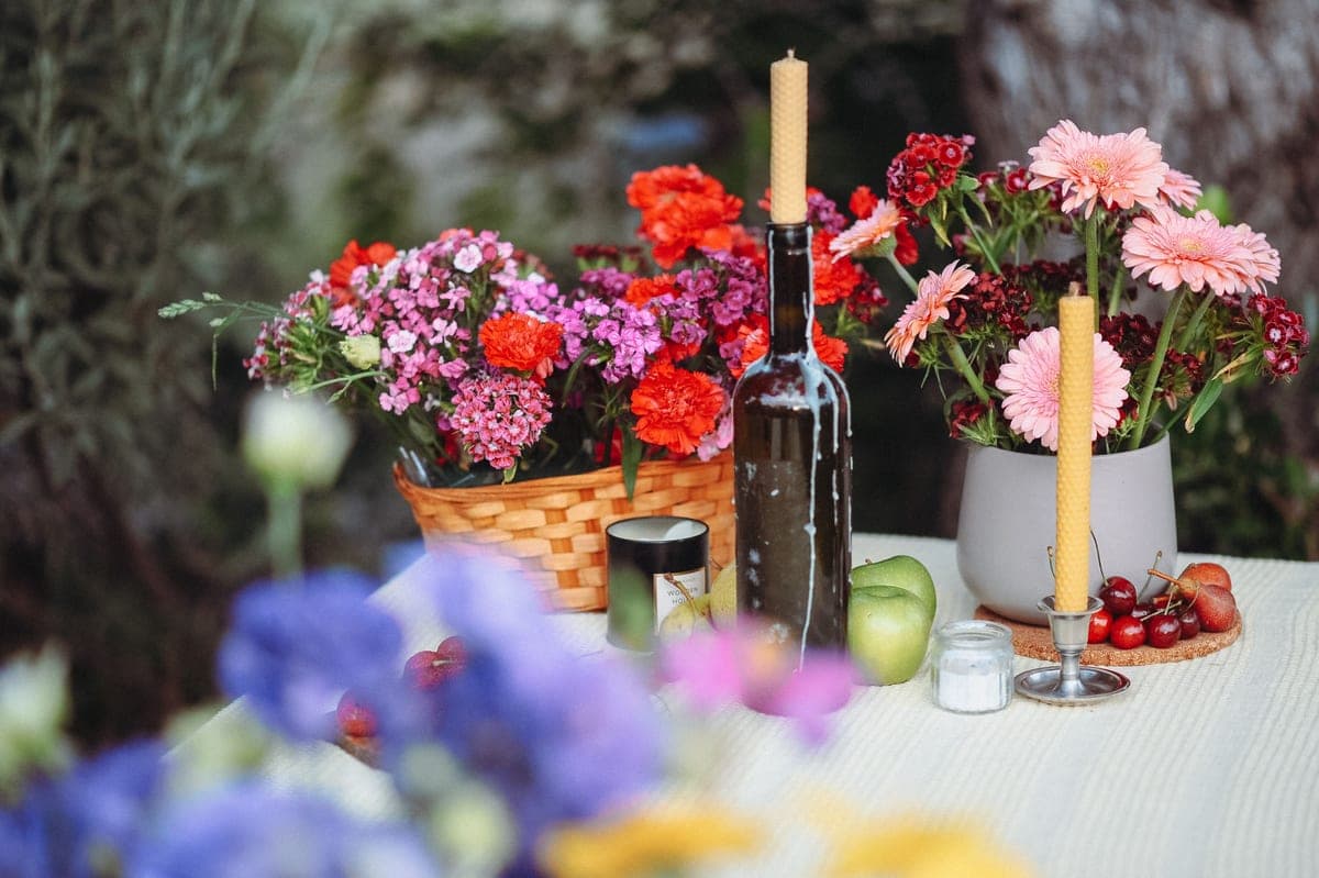 An outdoor table setting with flowers and candlesticks