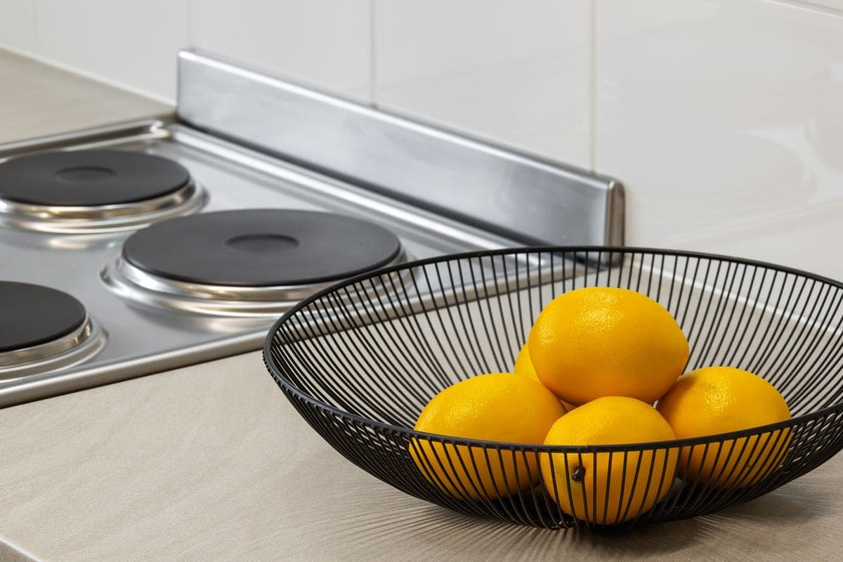Lemons in a metal bowl on a kitchen counter