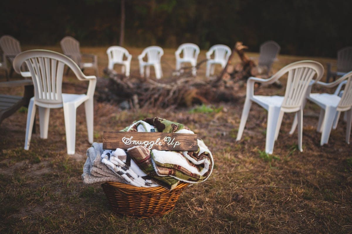 A campfire with chairs and blankets