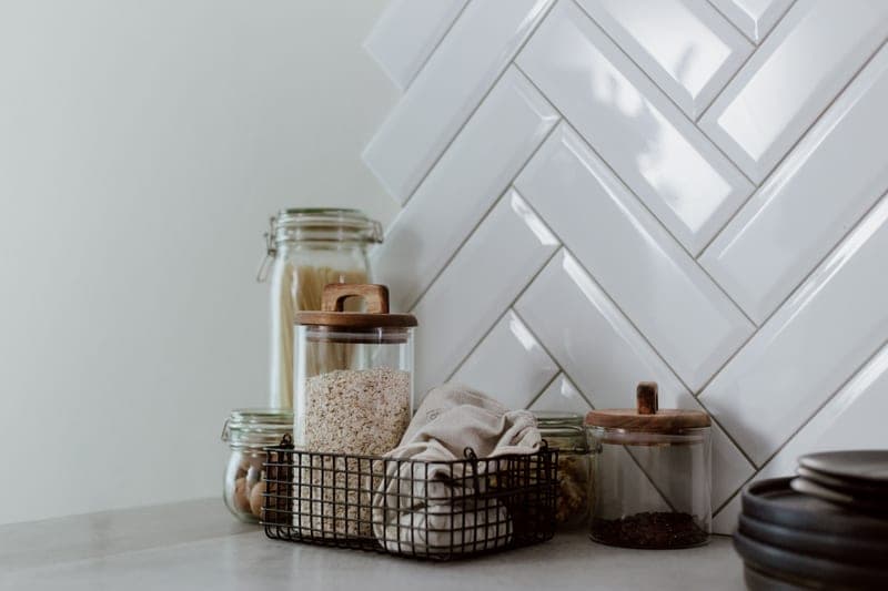 Glass storage jars of pasta and grains on a clean kitchen counter