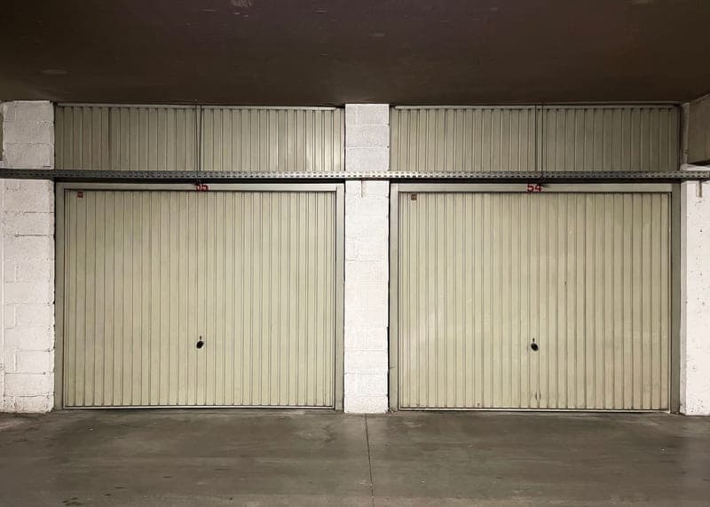 Closed garage doors inside an empty workshop space