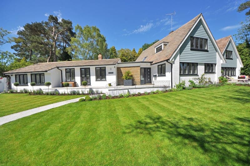 A contemporary house with a large manicured lawn and garden