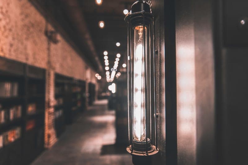 A dim corridor lit by exposed industrial light fittings
