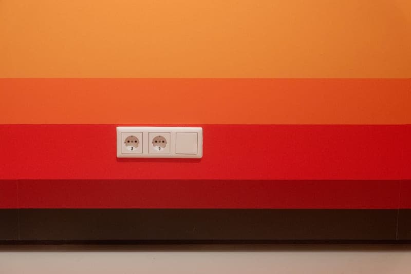 A pair of electrical sockets on a plain painted wall
