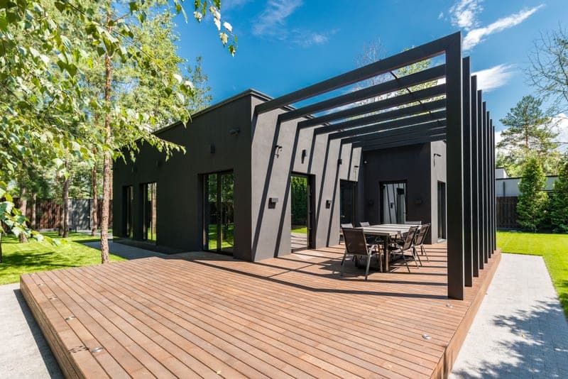A wooden deck and outdoor dining set surrounded by greenery