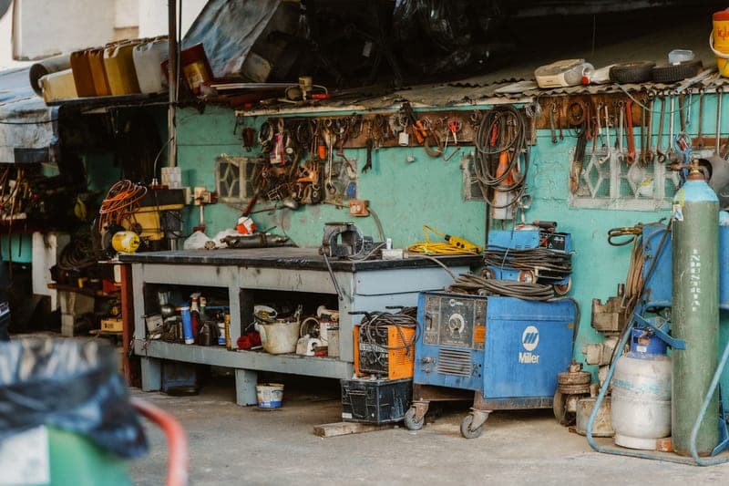 A cluttered workshop with tools hung along the wall