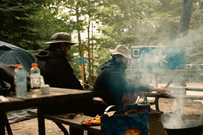 A campsite with tents and people cooking outdoors