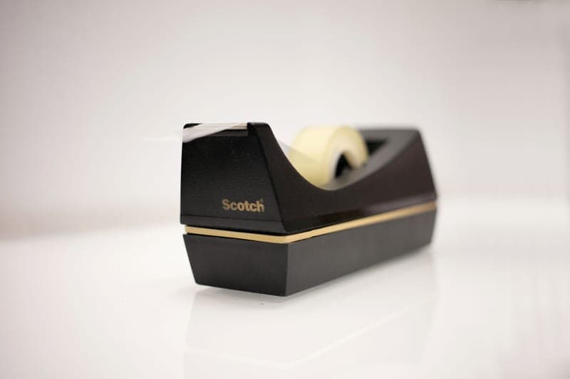A roll of black tape on a neutral background