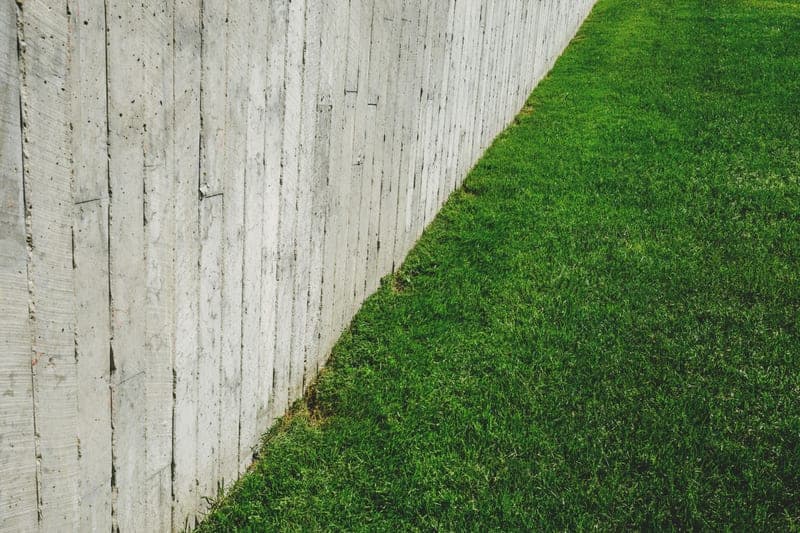 A wooden fence alongside a lush green lawn